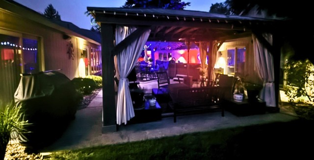 Lit pavilion and outdoor kitchen at night