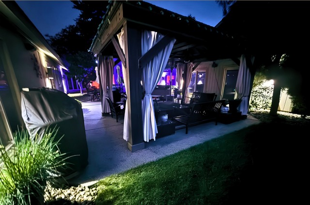 Lit pavilion and outdoor kitchen at night