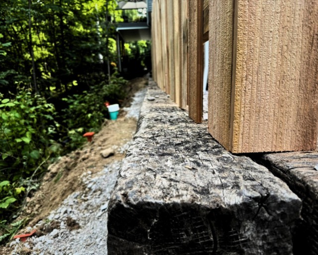 Detail of cedar post over rough stone wall