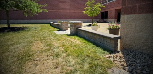 Stone capped low wall beside brick building