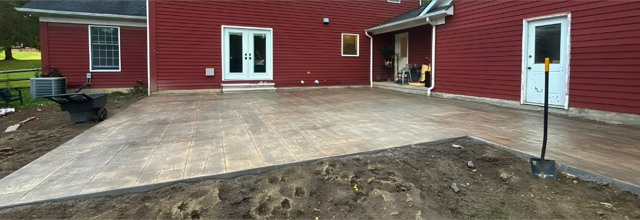 Red house with completed patterned concrete patio