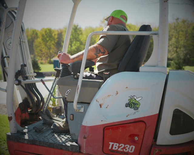 Excavator operator with rear equipment panel