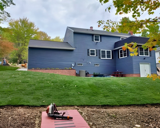 New lawn and grading beside gray house