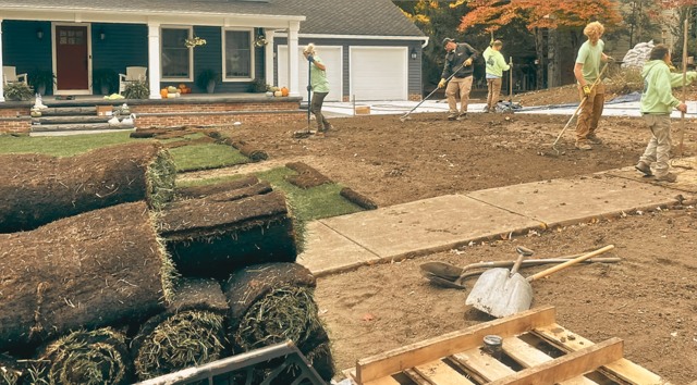 Crew leveling large gravel base in autumn