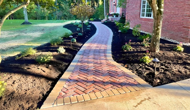 Curving brick walkway with fresh planting