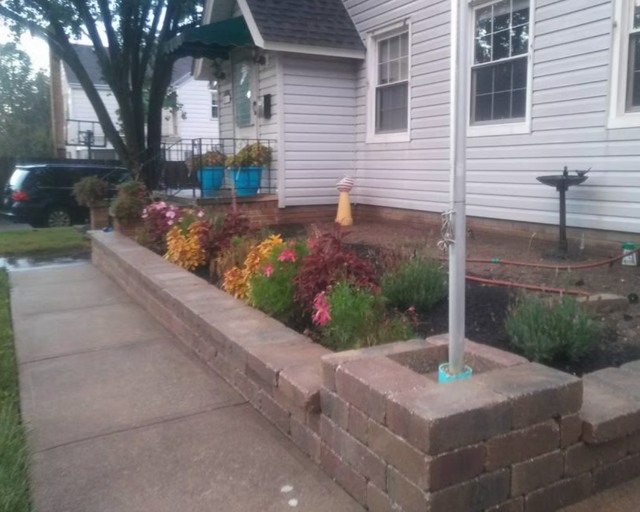 Raised masonry planter beside path